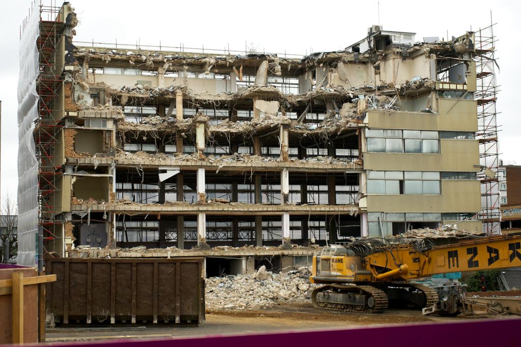 A large abandoned building undergoing demolition in England, showcasing damage and destruction.