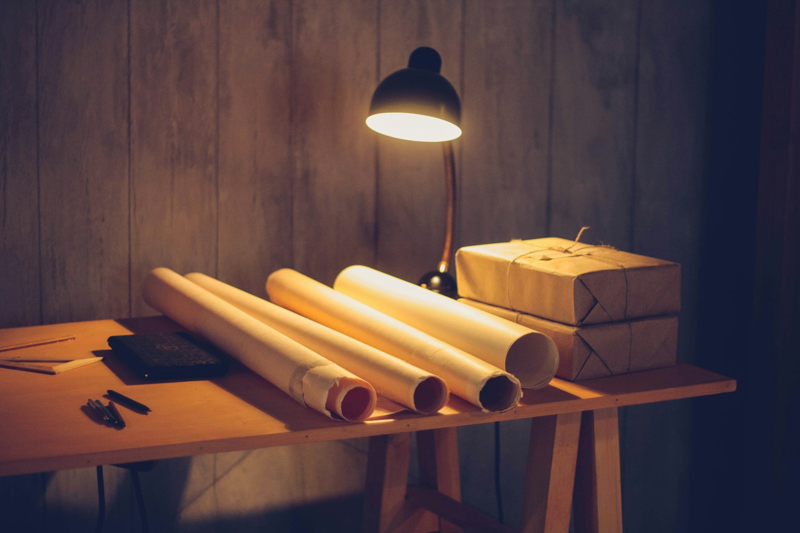 a table with a lamp and some rolls of paper on it